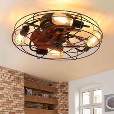 a ceiling light that is hanging from the ceiling in a living room with brick walls