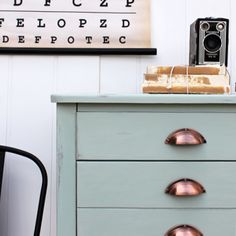 a blue dresser with an old camera on top