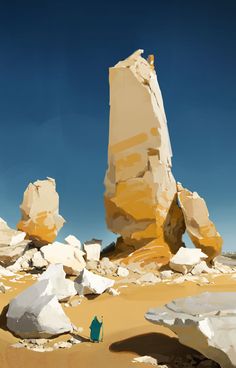 a person standing in front of some rocks and boulders on the beach with a blue sky behind them