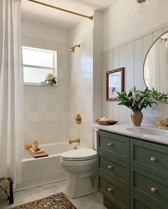 a bathroom with green cabinets and a white toilet