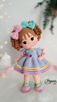 a crocheted doll is wearing a dress and shoes with a bow in her hair