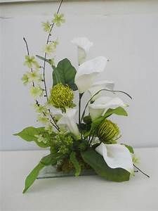 a vase filled with white flowers and greenery