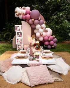 the table is set with pink and white balloons