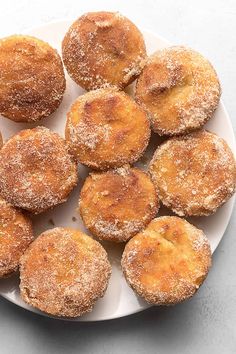 a white plate topped with powdered sugar covered pastries on top of a table