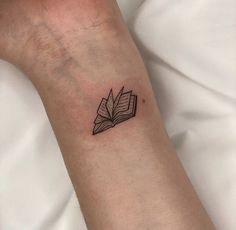 a small book tattoo on the wrist