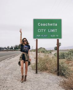 a woman is standing in front of a sign that says coachella city limit