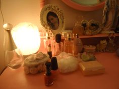 an assortment of cosmetics and perfume bottles sit on a table in front of a mirror