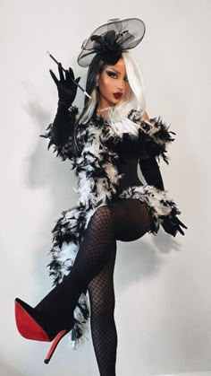 a woman dressed in black and white with feathers on her body is posing for the camera