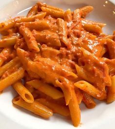 a white plate topped with pasta covered in sauce