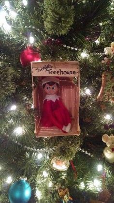 an elf in a box ornament hanging from a christmas tree