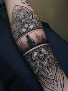 an arm with a black and white tattoo design on the left side of its arm