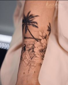 a woman's arm with flowers and palm trees on it