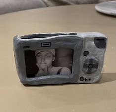 a small plastic game controller sitting on top of a table next to a person's face