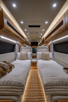 the inside of a luxury motor home with two beds and pillows on each side of the bed