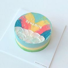 there is a cake that has been decorated with the word dynamite on it and rainbow colors