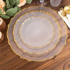 a table set with plates, silverware and gold utensils on top of it