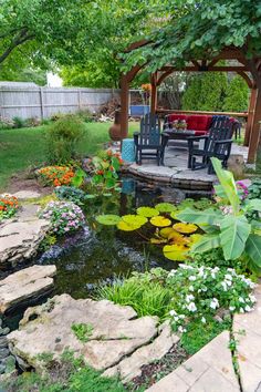 a small pond in the middle of a garden with chairs around it and flowers on the side