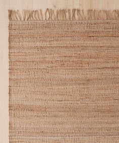 an area rug with fringes on the top and bottom of it, in light brown tones