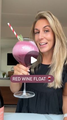 a woman holding up a wine glass with a pink drink in it and the words red wine float