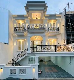 a large white house with lots of windows and balconies on the second floor