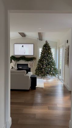 a living room filled with furniture and a christmas tree in the middle of the room