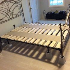 a metal bed frame with wooden slats on the bottom and foot boards attached to it