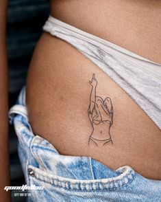 a woman's stomach with a small tattoo on the side of her belly that has a hand reaching up in the air