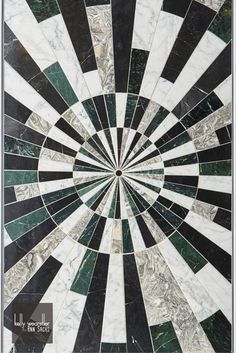 a black and white marble wall with a circular design in the center that is surrounded by smaller tiles