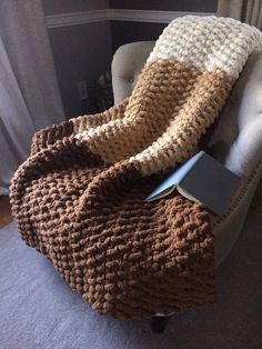 a brown and white blanket sitting on top of a chair