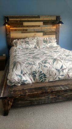 a bed made out of pallet wood with lights on the headboard and foot board