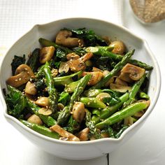 a white bowl filled with asparagus and mushrooms