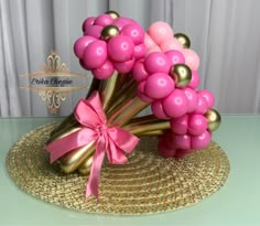 pink and gold balloon bouquet on top of a straw hat