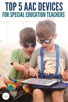 two young boys sitting next to each other on top of a table with an ipad