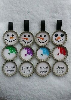 six bottle caps with snowmen on them and the names of each one in different colors