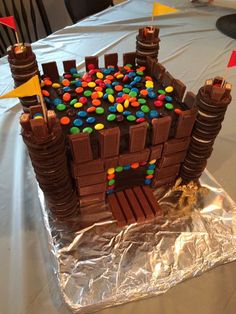 a cake made to look like a castle with lots of candy on top and flags sticking out of it