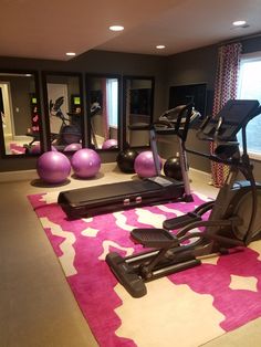 there is a gym with exercise equipment in the room, and mirrors on the wall