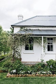 a white house with ivy growing on the roof