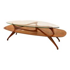 a glass and wood coffee table with an oval shaped base on one end, in the shape of a wave