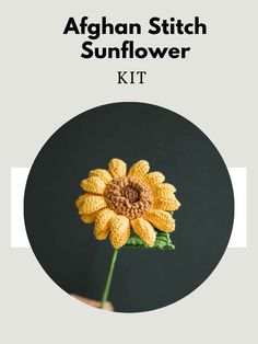 the afghan stitch sunflower kit is shown in front of a black background with an orange flower