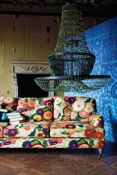 a colorful couch sitting in front of a chandelier