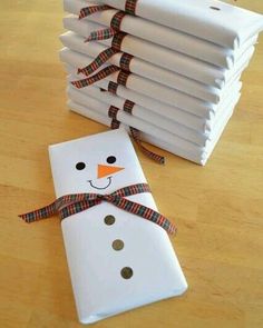 a snowman made out of napkins sitting on top of a wooden table next to a stack of folded paper