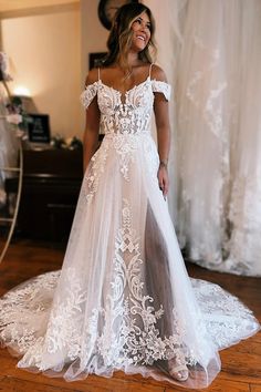 a woman in a white wedding dress standing on a wooden floor