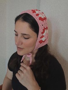 a woman wearing a pink crocheted head scarf