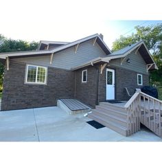 a gray house with stairs leading to the front door