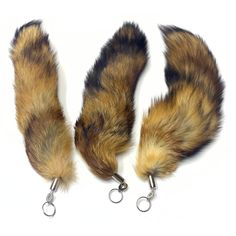 three furry animal tail clips are shown on a white background