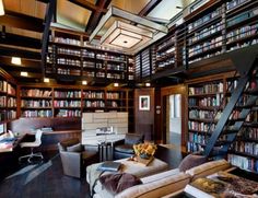 a living room filled with lots of furniture and bookshelves next to a staircase