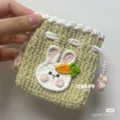 someone is holding up a small crocheted bag with a rabbit on it's face