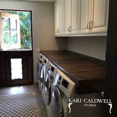 a washer and dryer in a room with white cabinets