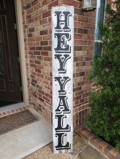 a wooden sign that says happy friday on it in front of a brick wall and door