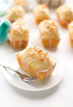 a white plate topped with muffins covered in frosting